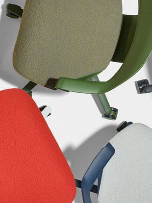 Rear view of a graphite Aeron office chair, showing back support and adjustable arms.